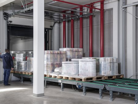 Loading units with plastic packaging films on chain conveyors of the automated loading and unloading system from delo: Dettmer Verpackungen GmbH & Co. KG, Lohne, Lower Saxony