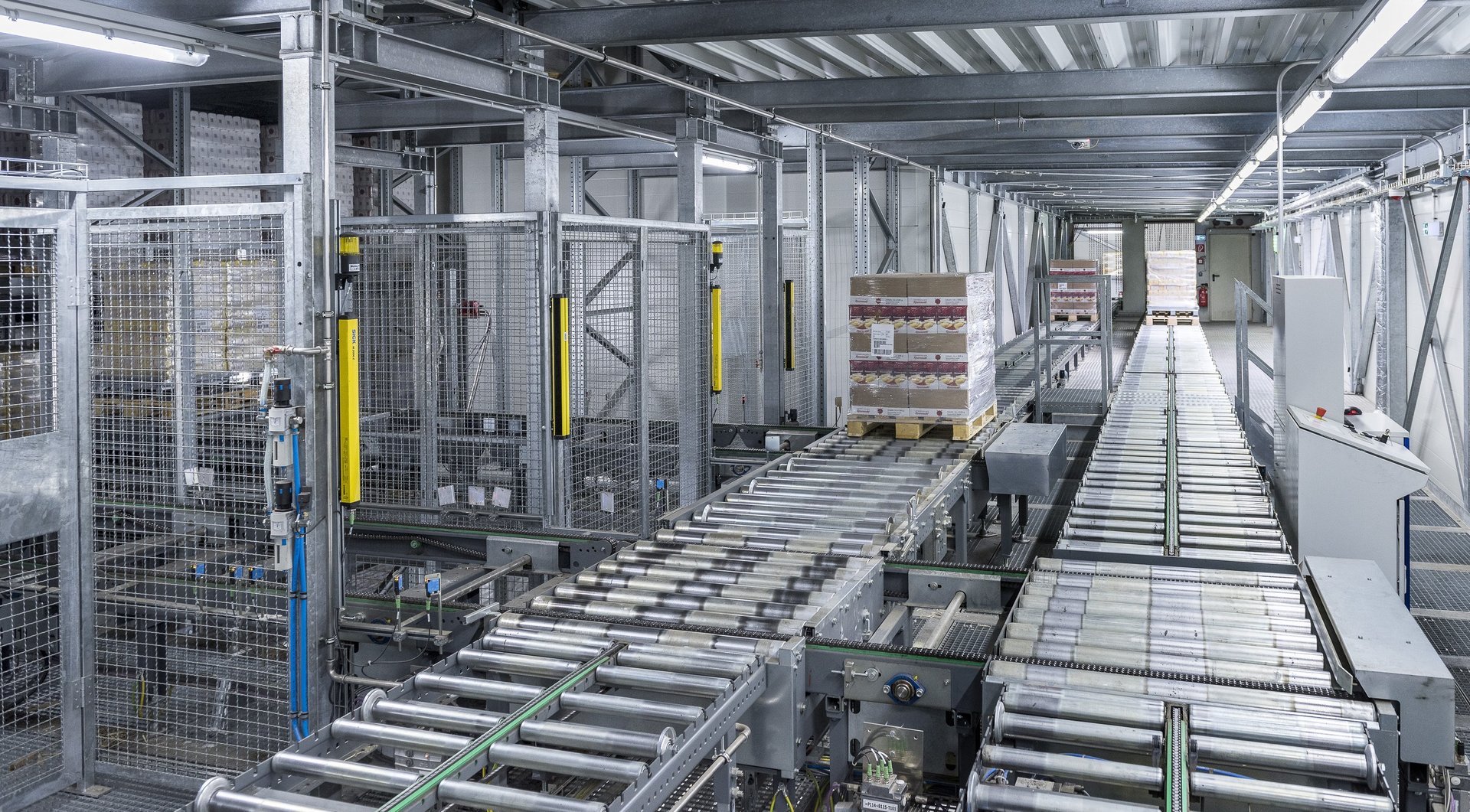 Software-controlled roller conveyors in an automated storage system