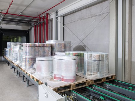 Loading units with plastic packaging films on chain conveyors of the automated loading and unloading system from delo: Dettmer Verpackungen GmbH & Co. KG, Lohne, Lower Saxony