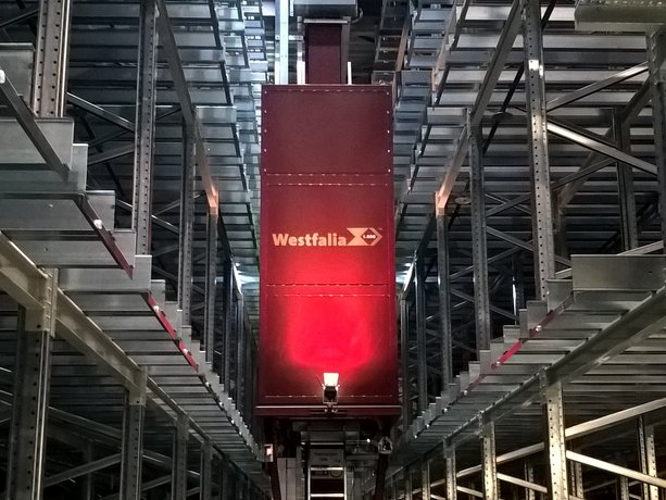 Storage and retrieval machine in the storage aisle of an automated high-bay warehouse, Läderach (Schweiz) AG