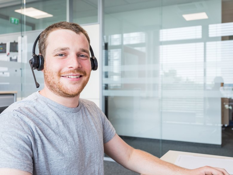 Ein Mitarbeiter steht per Headset für Kundenanfragen in der 24/7-Hotline zur Verfügung, Westfalia Technologies GmbH & Co. KG, Borgholzhausen